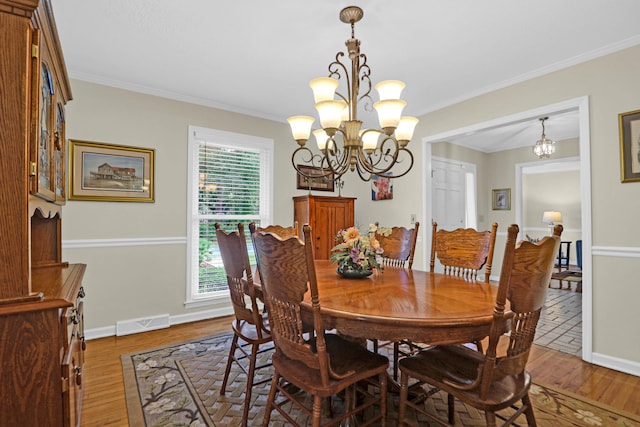 dining room with a chandelier, wood finished floors, and visible vents