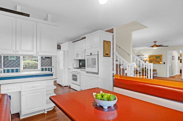 kitchen featuring white appliances, dark wood-type flooring, and white cabinetry