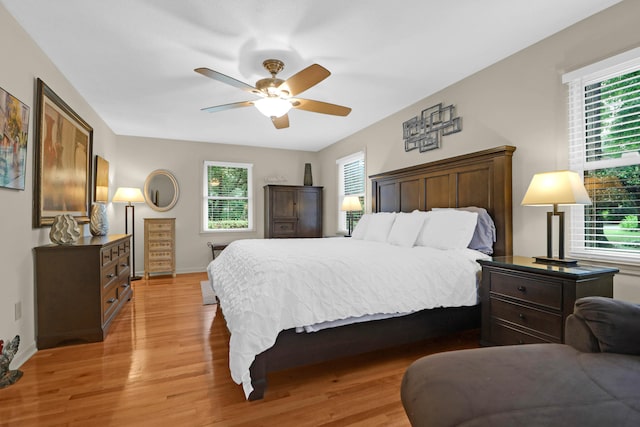 bedroom featuring a ceiling fan, baseboards, and light wood finished floors