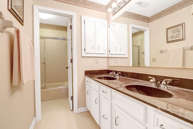 full bath featuring enclosed tub / shower combo, a sink, baseboards, and double vanity