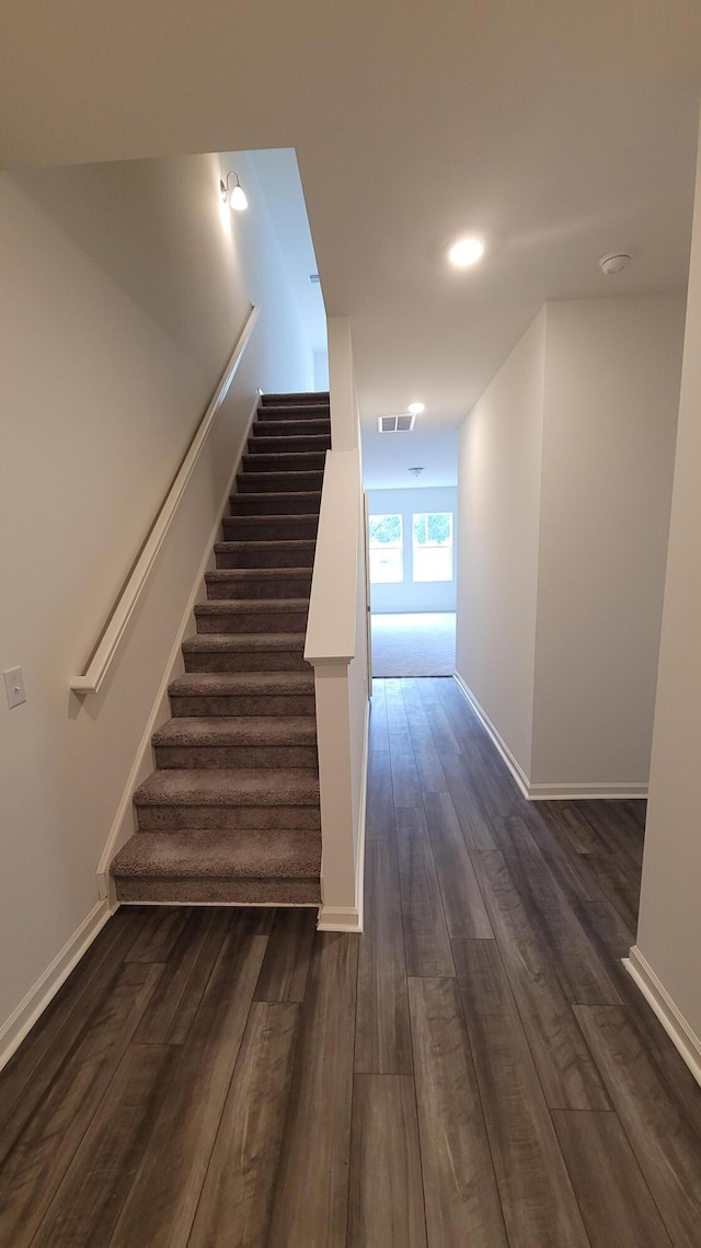 staircase with wood finished floors and baseboards