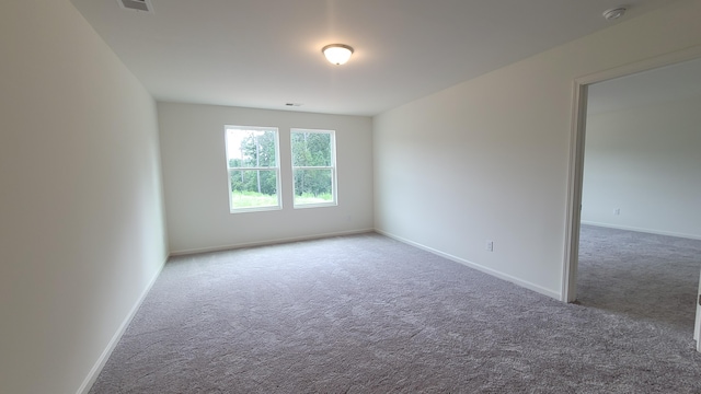 spare room featuring carpet, a smoke detector, and baseboards