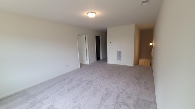 carpeted spare room featuring baseboards