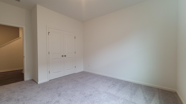 unfurnished bedroom with carpet, baseboards, and a closet