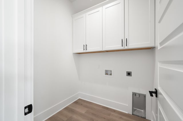 laundry area featuring electric dryer hookup, hookup for a washing machine, cabinets, and wood-type flooring