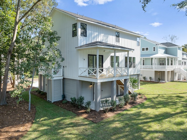 rear view of house featuring a sunroom, a yard, and a balcony