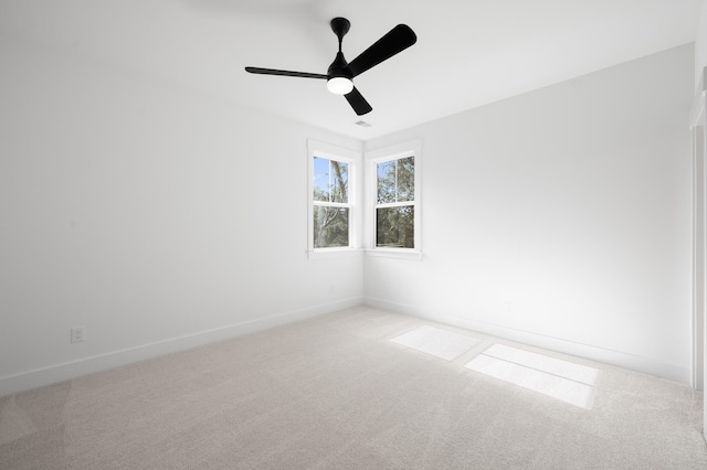 unfurnished room with light colored carpet and ceiling fan