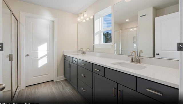 bathroom with walk in shower, vanity, and wood-type flooring