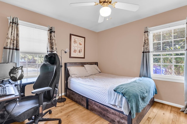 bedroom featuring ceiling fan, baseboards, and wood finished floors