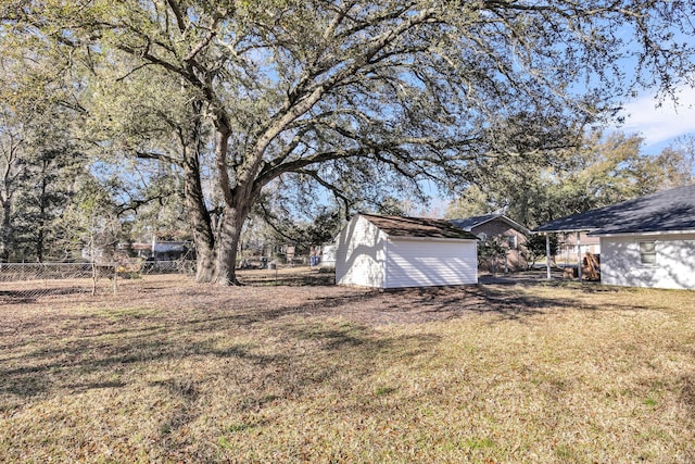 view of yard featuring an outbuilding, a storage shed, and fence