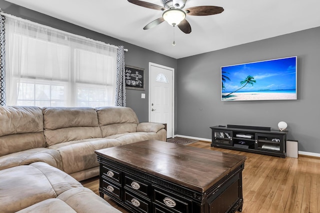 living room with baseboards, light wood-type flooring, and ceiling fan