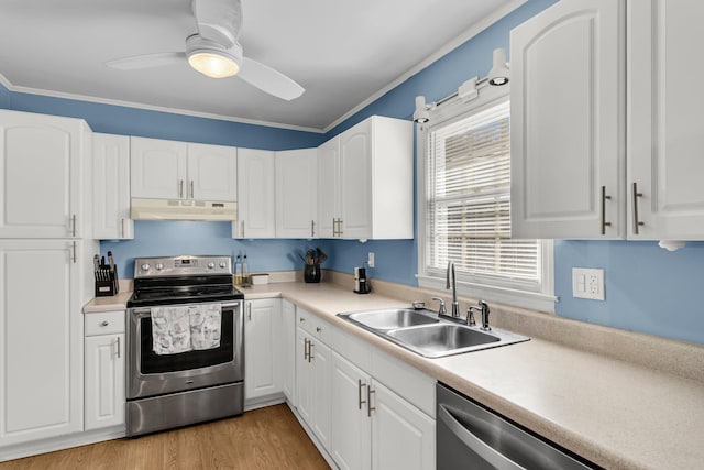 kitchen with under cabinet range hood, appliances with stainless steel finishes, white cabinets, and a sink