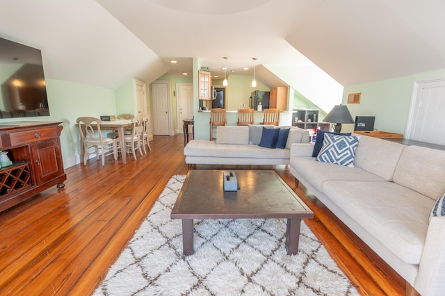 living room with light hardwood / wood-style floors and vaulted ceiling