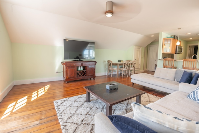 living room with wood-type flooring, lofted ceiling, and ceiling fan