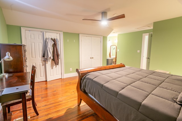 bedroom featuring wood-type flooring, multiple closets, and ceiling fan