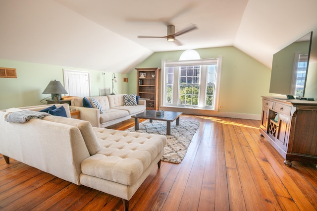 living room featuring ceiling fan, light hardwood / wood-style flooring, and vaulted ceiling