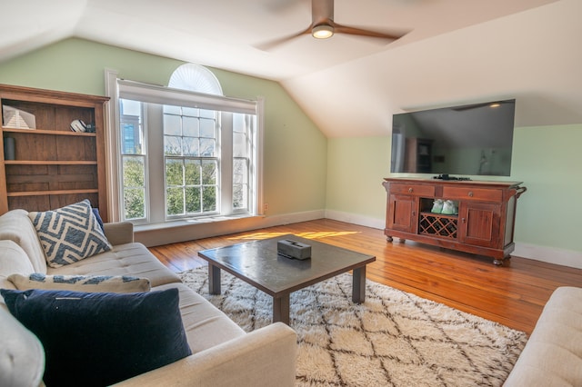 living room with ceiling fan, light hardwood / wood-style flooring, and vaulted ceiling