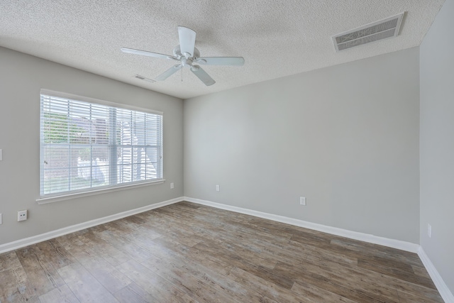 spare room with visible vents, baseboards, ceiling fan, and wood finished floors