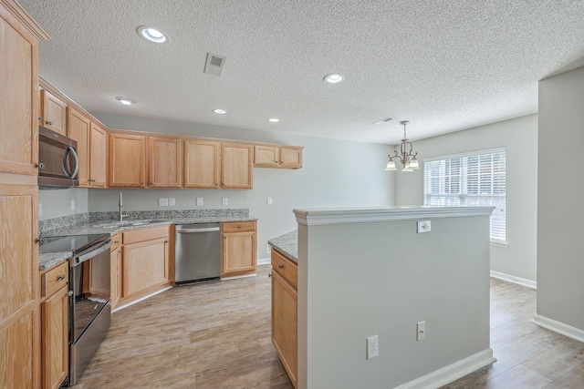 kitchen featuring a kitchen island, a chandelier, light wood-style floors, stainless steel appliances, and a sink