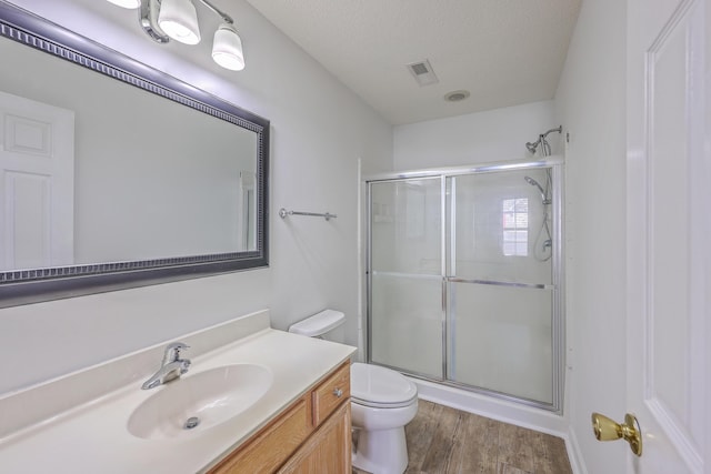 full bath featuring visible vents, a stall shower, toilet, and vanity