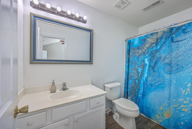 bathroom with visible vents, a textured ceiling, wood finished floors, and toilet