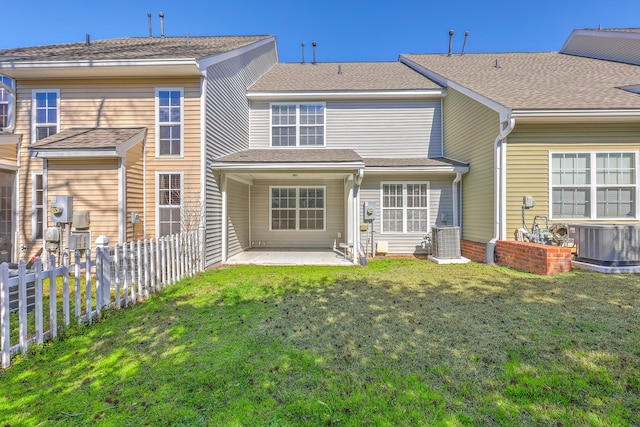 rear view of property with a yard, fence, central AC unit, and a patio area