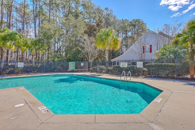 pool with a patio and fence