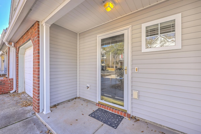 entrance to property with brick siding and an attached garage