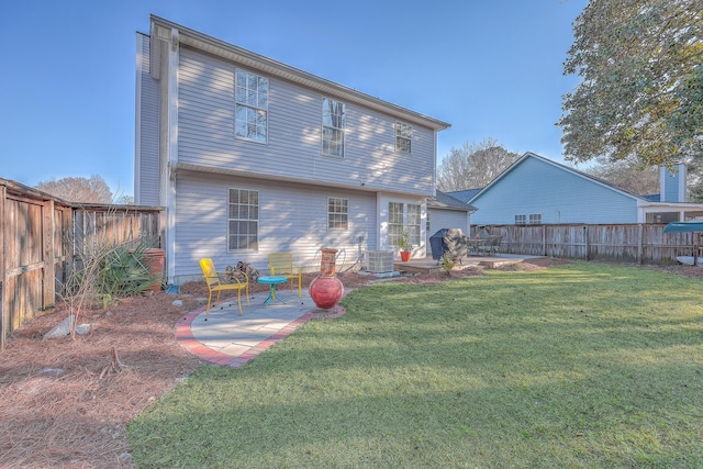 rear view of property with a yard, central AC unit, a patio area, and a fenced backyard