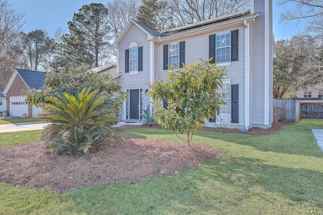 colonial house featuring a chimney, roof mounted solar panels, fence, driveway, and a front lawn