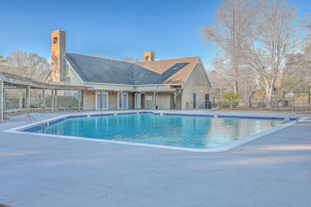 community pool with fence and a patio