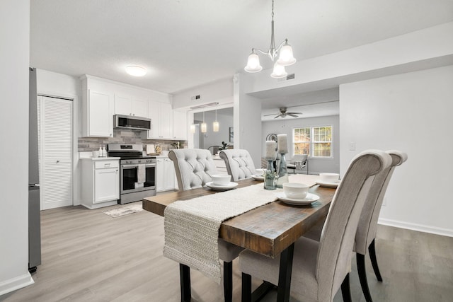 dining space with a chandelier, a ceiling fan, light wood-type flooring, and baseboards