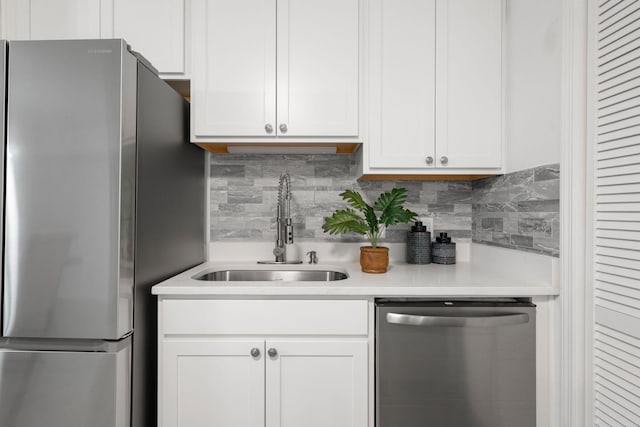 kitchen featuring stainless steel appliances, a sink, light countertops, and decorative backsplash
