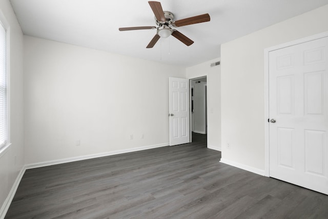 unfurnished bedroom featuring dark wood-type flooring, baseboards, and ceiling fan