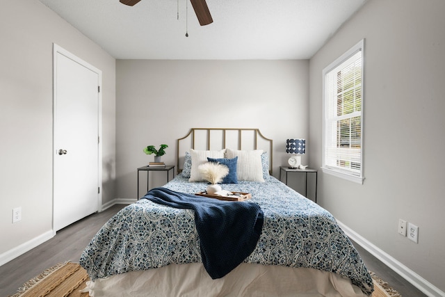 bedroom with wood finished floors, baseboards, and a ceiling fan