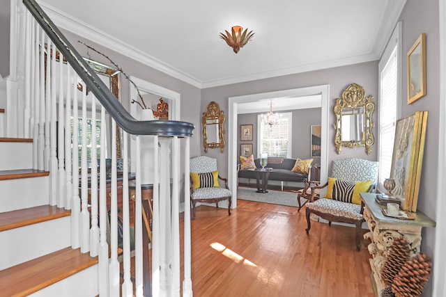 interior space featuring a chandelier, wood finished floors, crown molding, and stairs