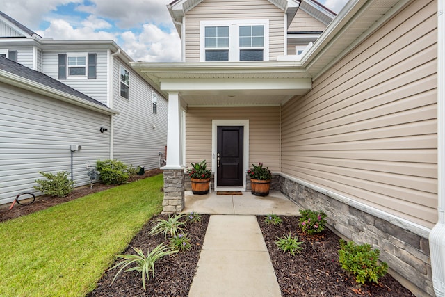 property entrance with a lawn