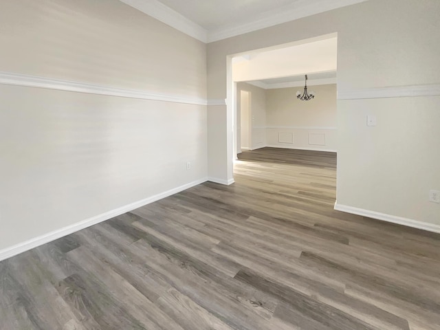 unfurnished room with crown molding, a notable chandelier, and dark hardwood / wood-style flooring