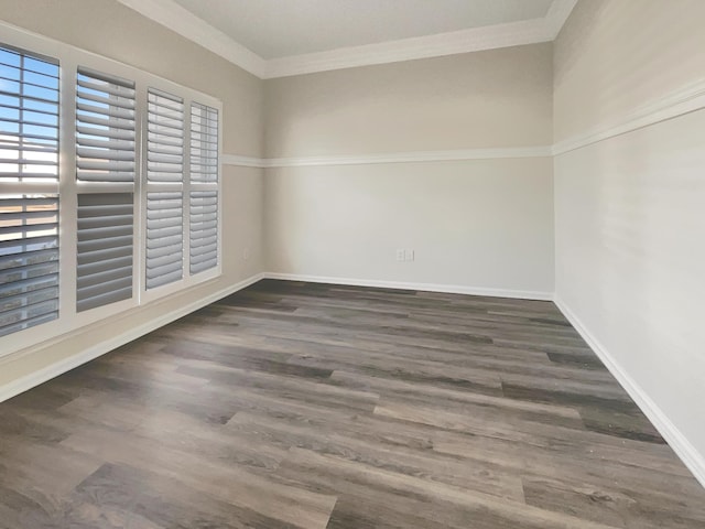 empty room featuring dark wood-type flooring and ornamental molding