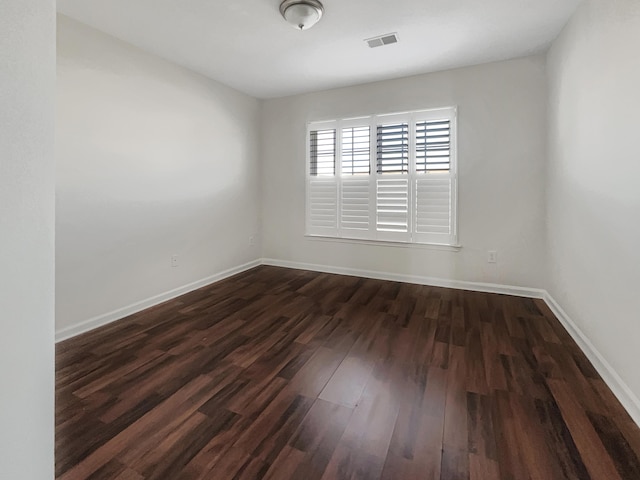 spare room featuring dark wood-type flooring