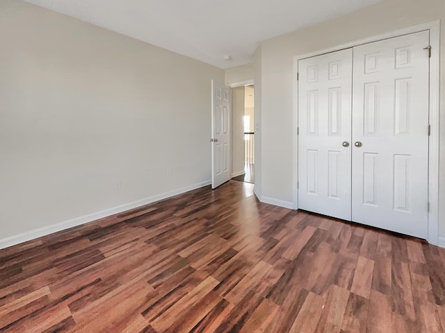 unfurnished bedroom with a closet and dark hardwood / wood-style floors