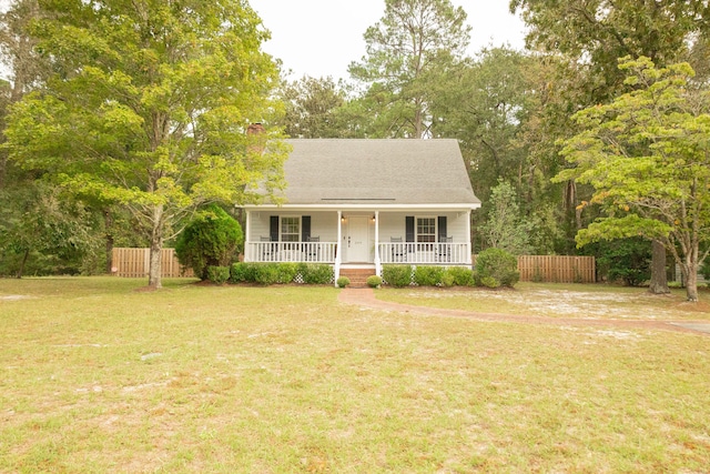 ranch-style home featuring a front lawn and covered porch