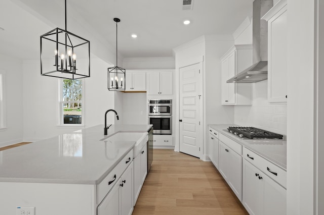 100 E Carolina Ave, Summerville, SC 29483 - kitchen with wall chimney exhaust hood, stainless steel appliances, a chandelier, recessed lighting, and white cabinets