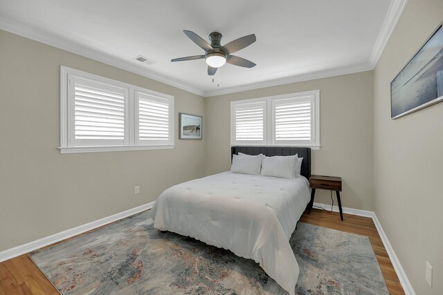 bedroom featuring ceiling fan, dark hardwood / wood-style flooring, and ornamental molding