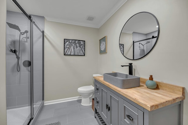 bathroom with toilet, vanity, tile patterned floors, and crown molding