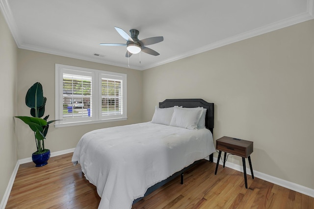 bedroom featuring ceiling fan, wood-type flooring, and ornamental molding