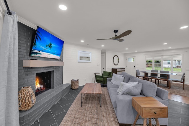 living room with dark hardwood / wood-style floors, a brick fireplace, and ceiling fan