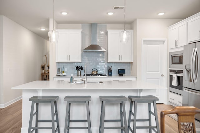 291 Lucca Dr, Summerville, SC 29486 - kitchen featuring stainless steel appliances, wall chimney range hood, backsplash, a breakfast bar area, and recessed lighting