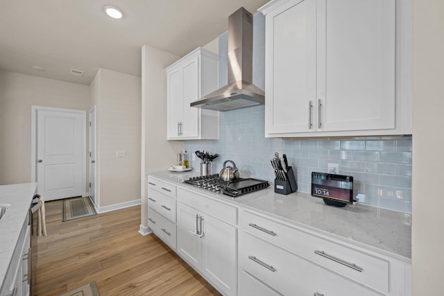 291 Lucca Dr, Summerville, SC 29486 - kitchen featuring wall chimney range hood, stainless steel gas cooktop, white cabinets, light wood-style flooring, and tasteful backsplash