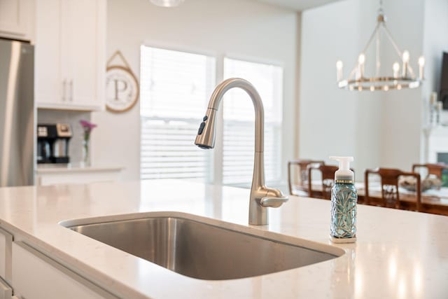 291 Lucca Dr, Summerville, SC 29486 - kitchen view of white cabinets, light stone counters, pendant lighting, freestanding refrigerator, and a chandelier